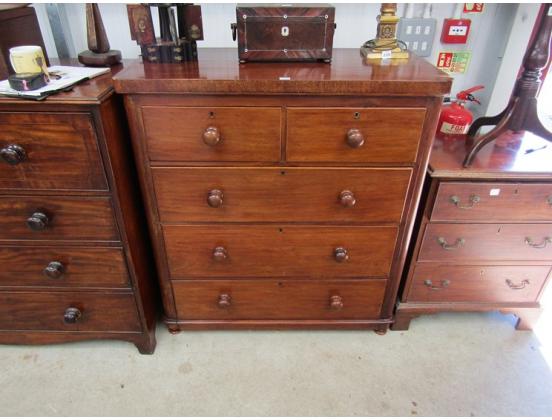 An antique chest of drawers in an auction