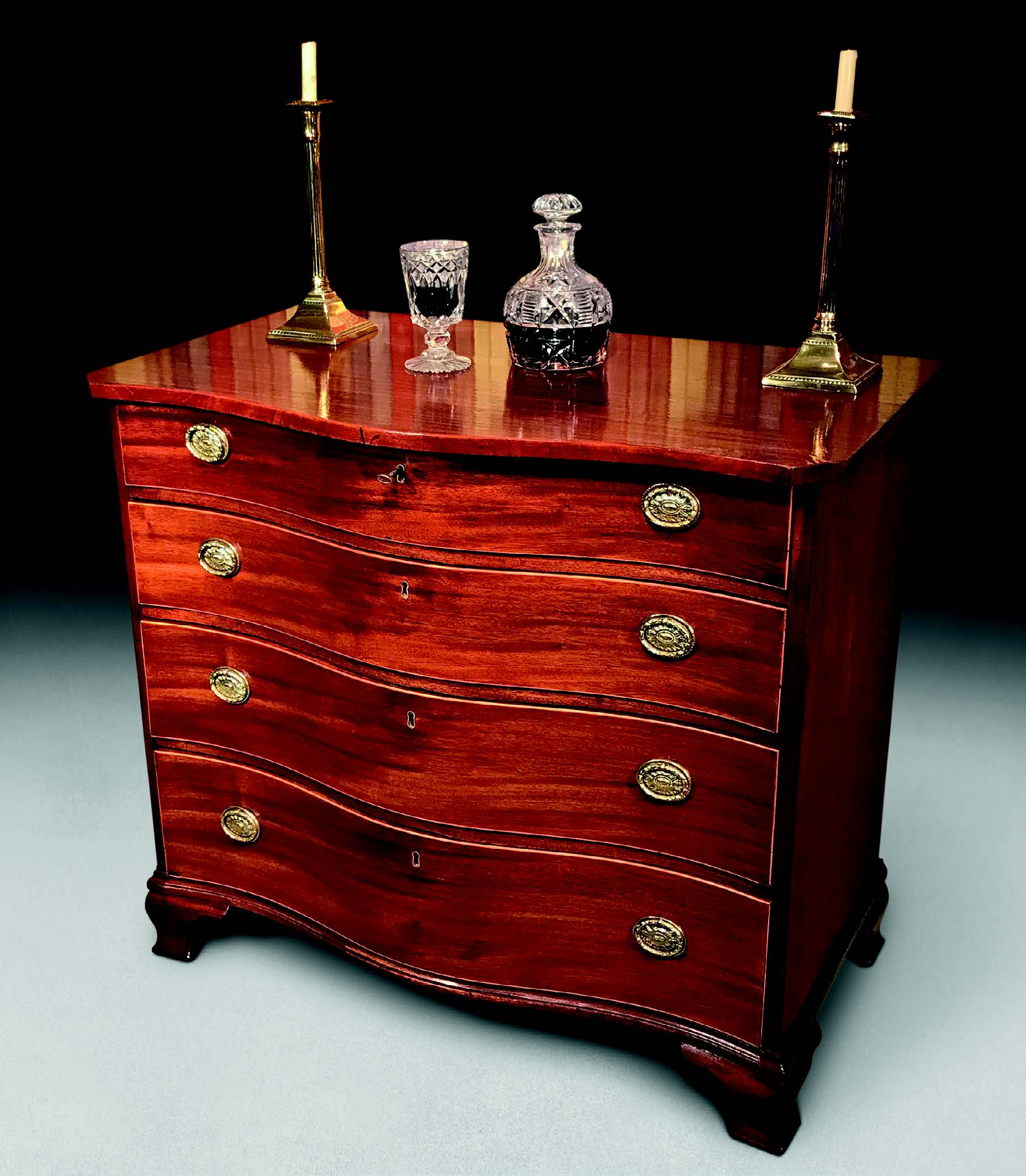 A George III mahogany serpentine chest of drawers, c.1780, with original oval plate handles