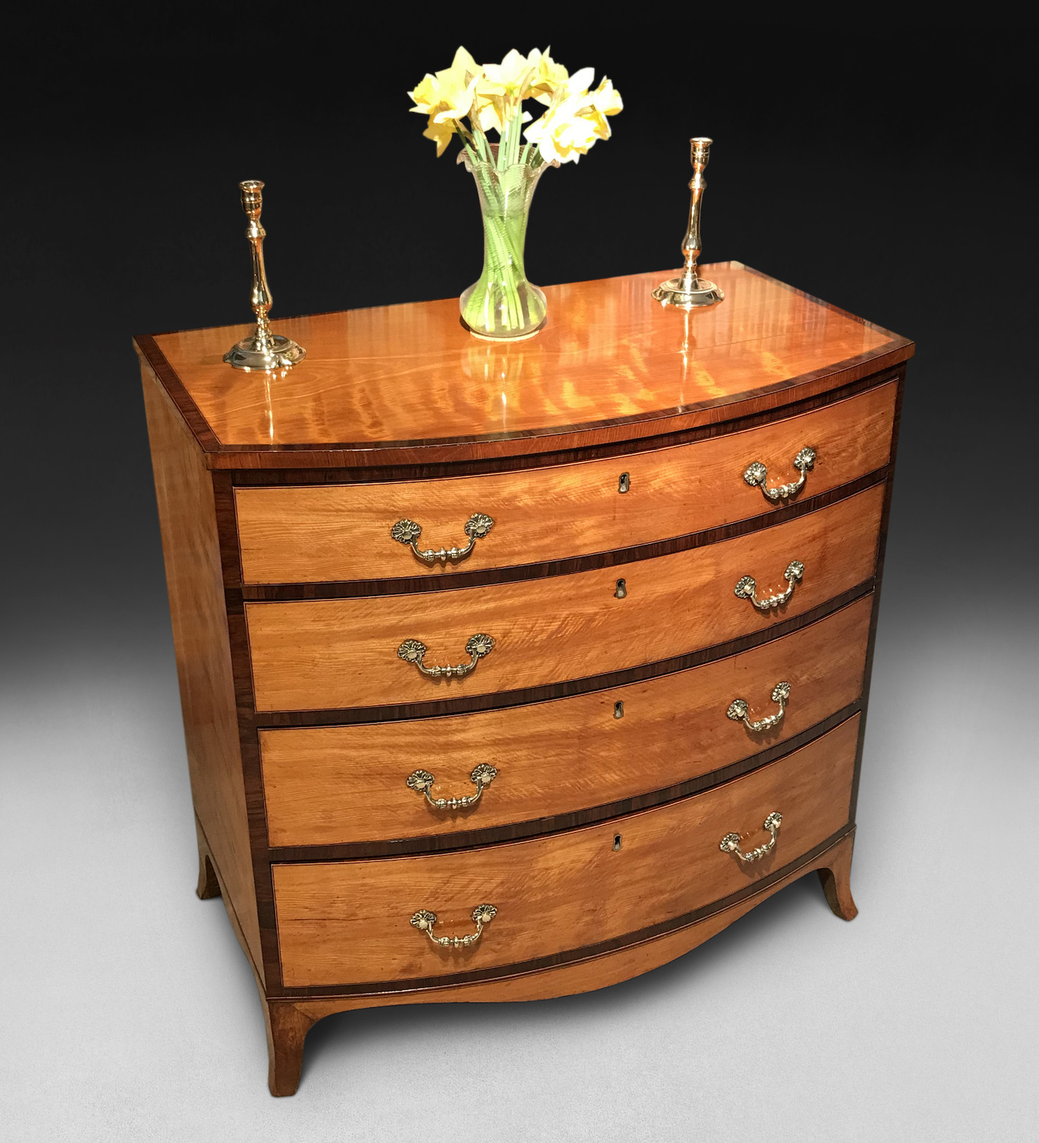 A George III period satinwood and kingwood crossbanded bow fronted chest of drawers