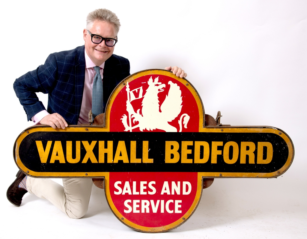 Auctioneer Richard Bromell with a vintage Vauxhall Bedford Sales and Service enamel sign