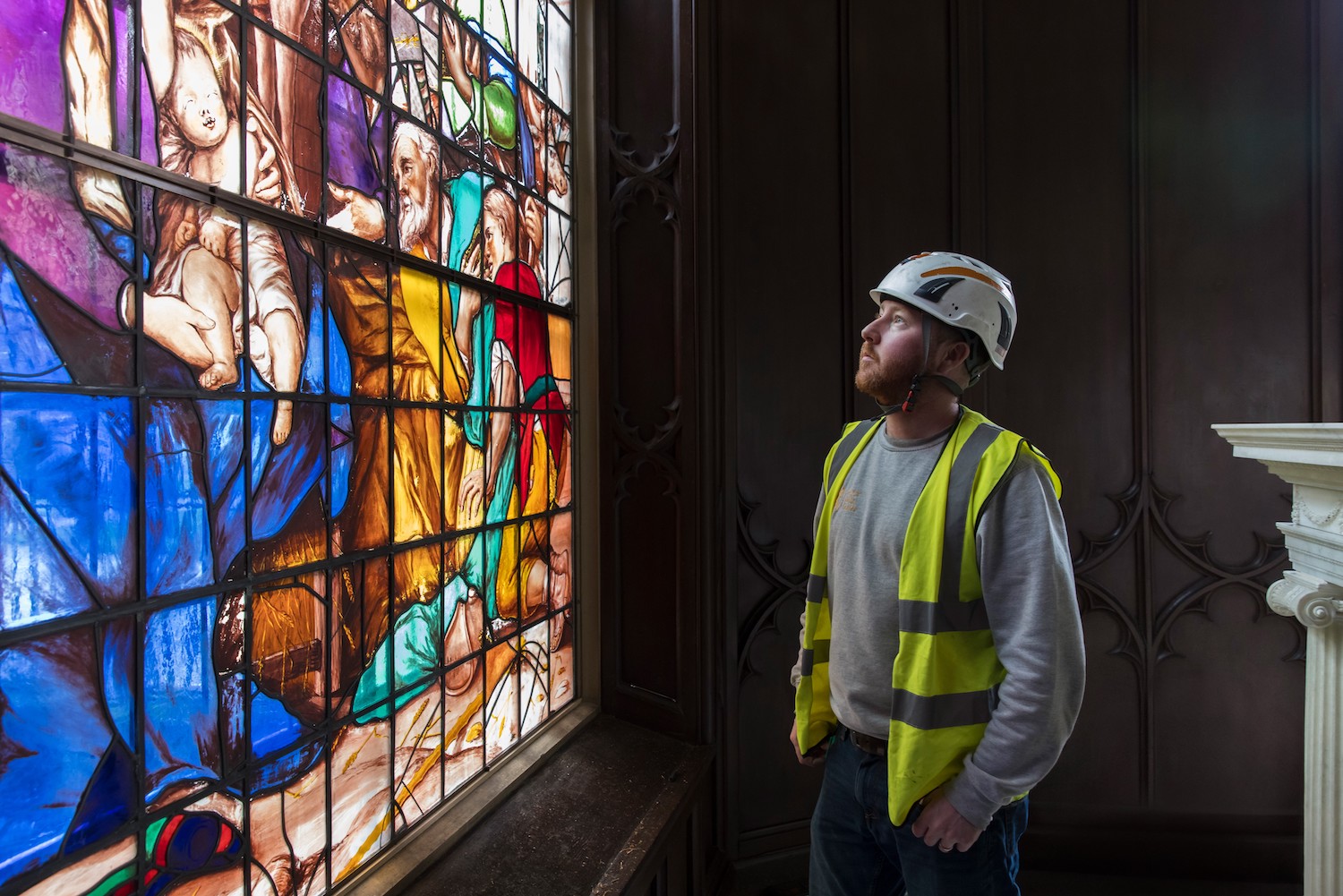 A workman inspecting The Vyne stained glass