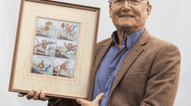 Auctioneer Adrian Kinton with a Louis Wain watercolour of two cats fishing for eels