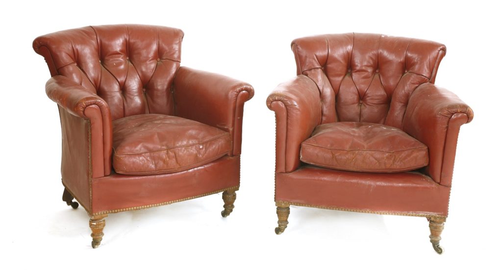 A pair of antique Victorian crimson leather armchairs