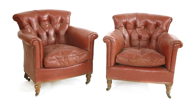 A pair of Victorian crimson leather armchairs