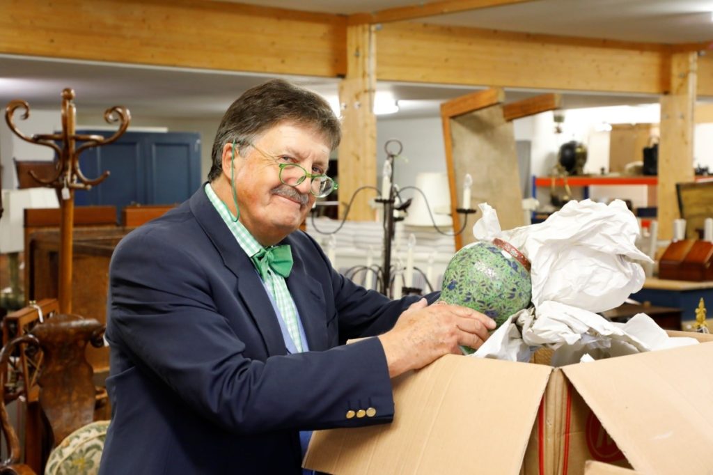 Tim Wonnacott unpacking items for sale in auction room